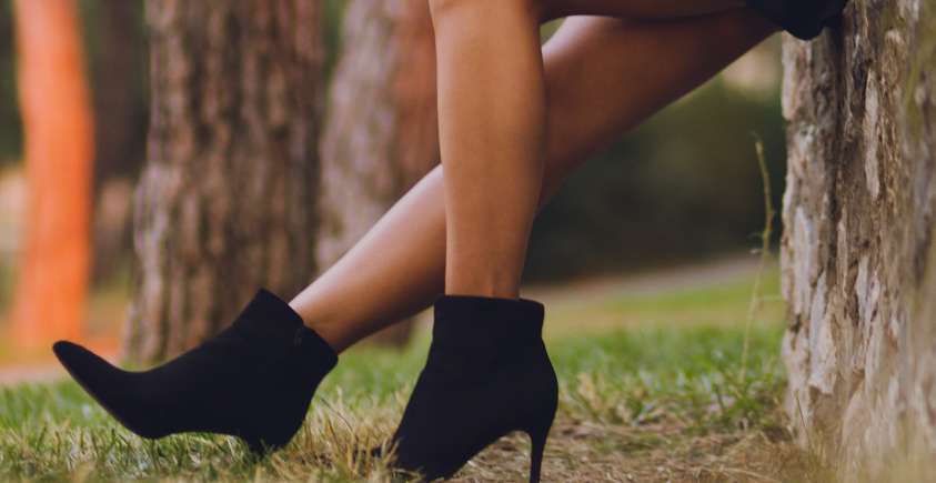 kobieta w czarnej sukience i butach na obcasie