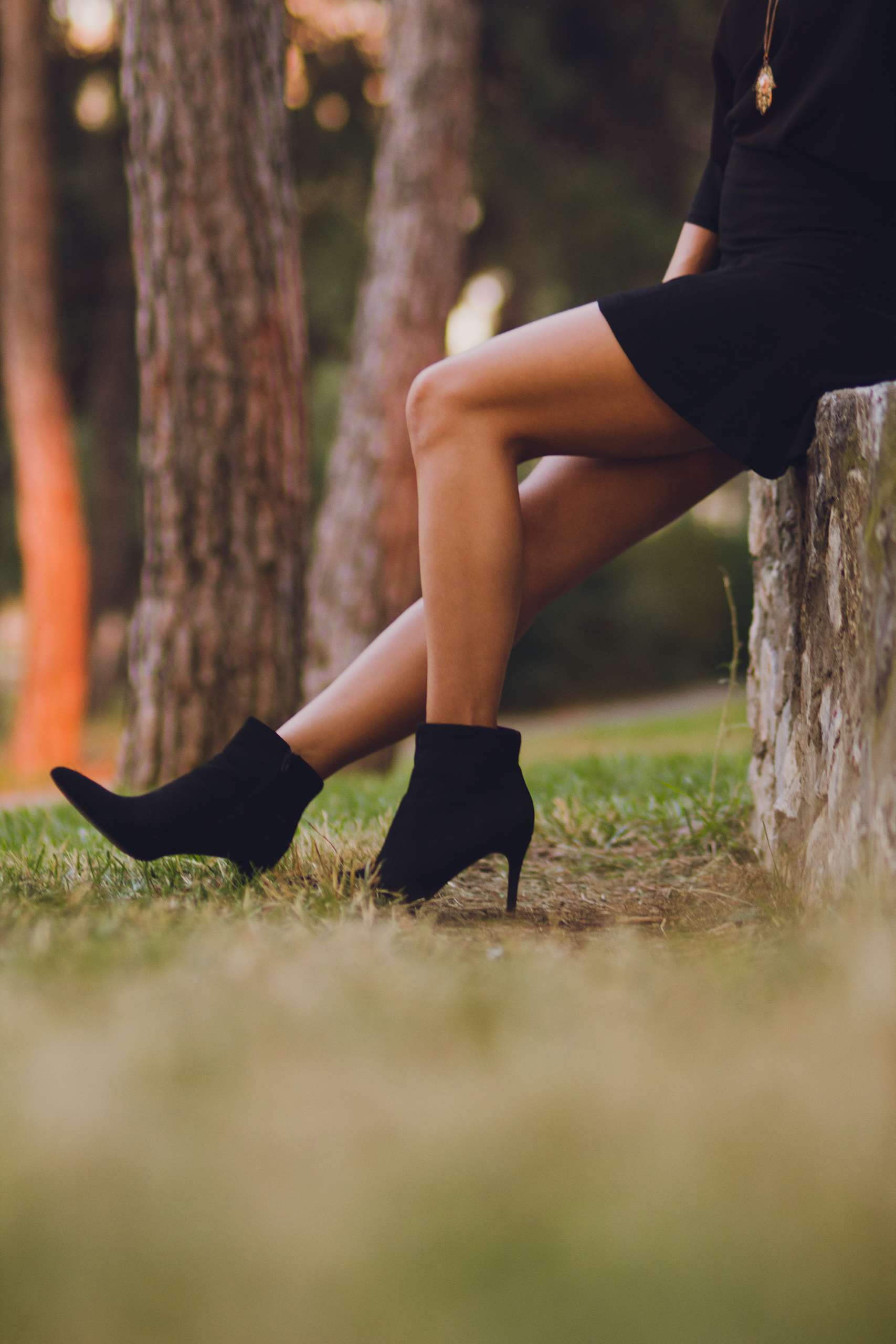 kobieta w czarnej sukience i butach na obcasie
